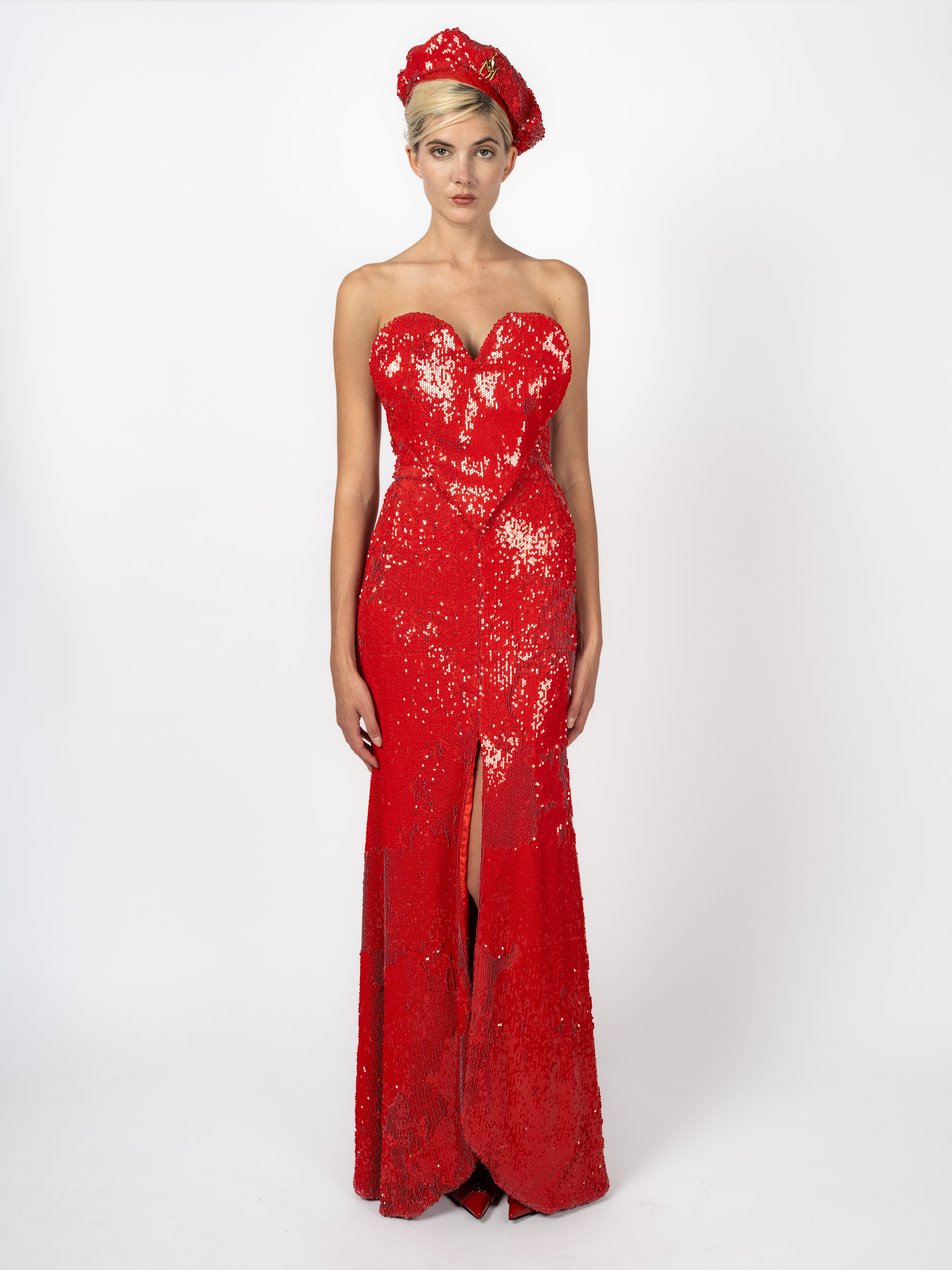 Bodenlanges, trägerloses Abendkleid in Rot mit Pailletten und Herz-Corsage, dazu Pailletten-Beret, von Maya Seyferth