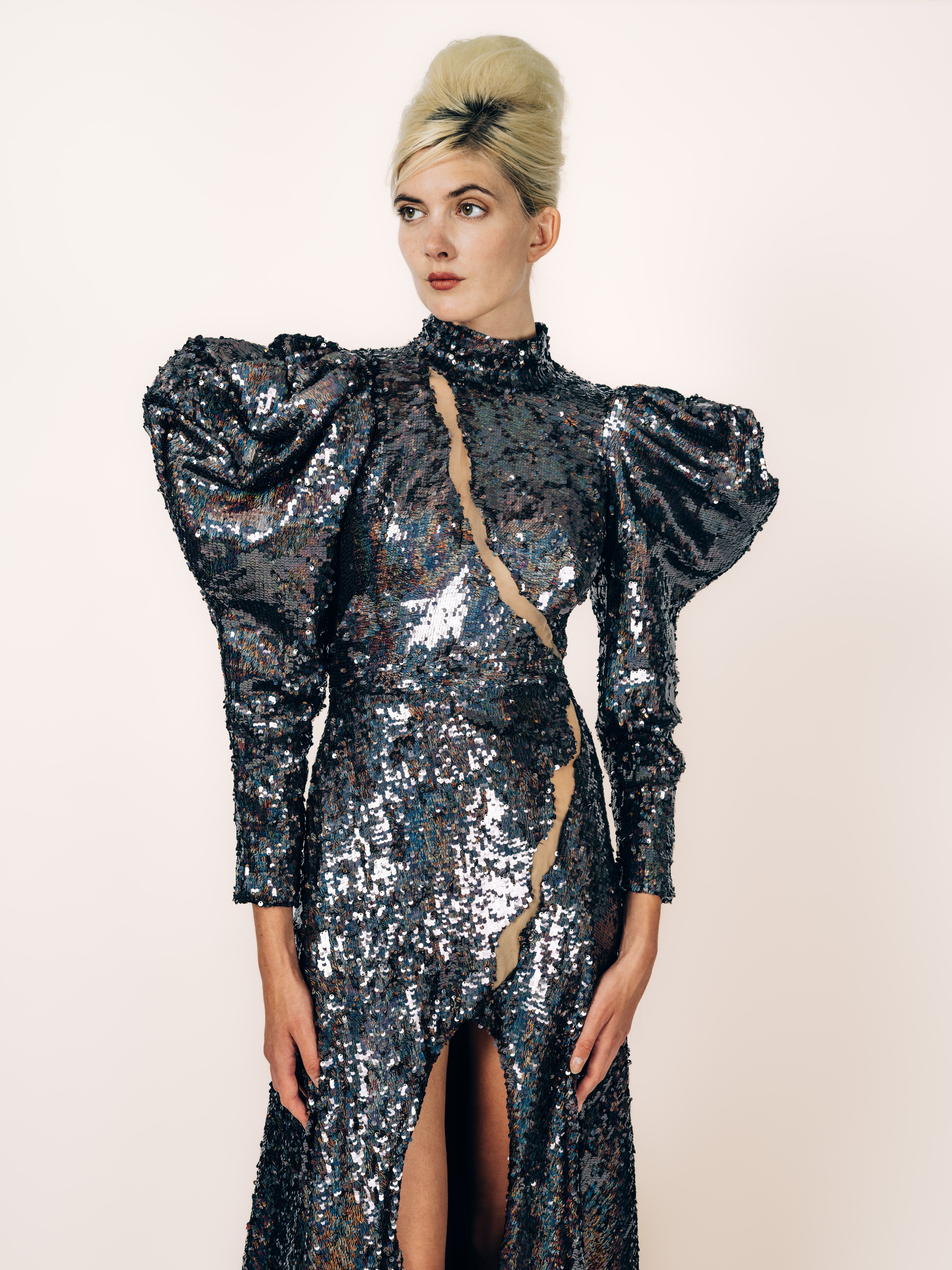 Bodenlanges Abendkleid Schwarz-Holo aus holografisch schimmernden Pailletten mit skulpturalen Puffärmeln, transparentem Einsatz und Beinschlitz von Maya Seyferth