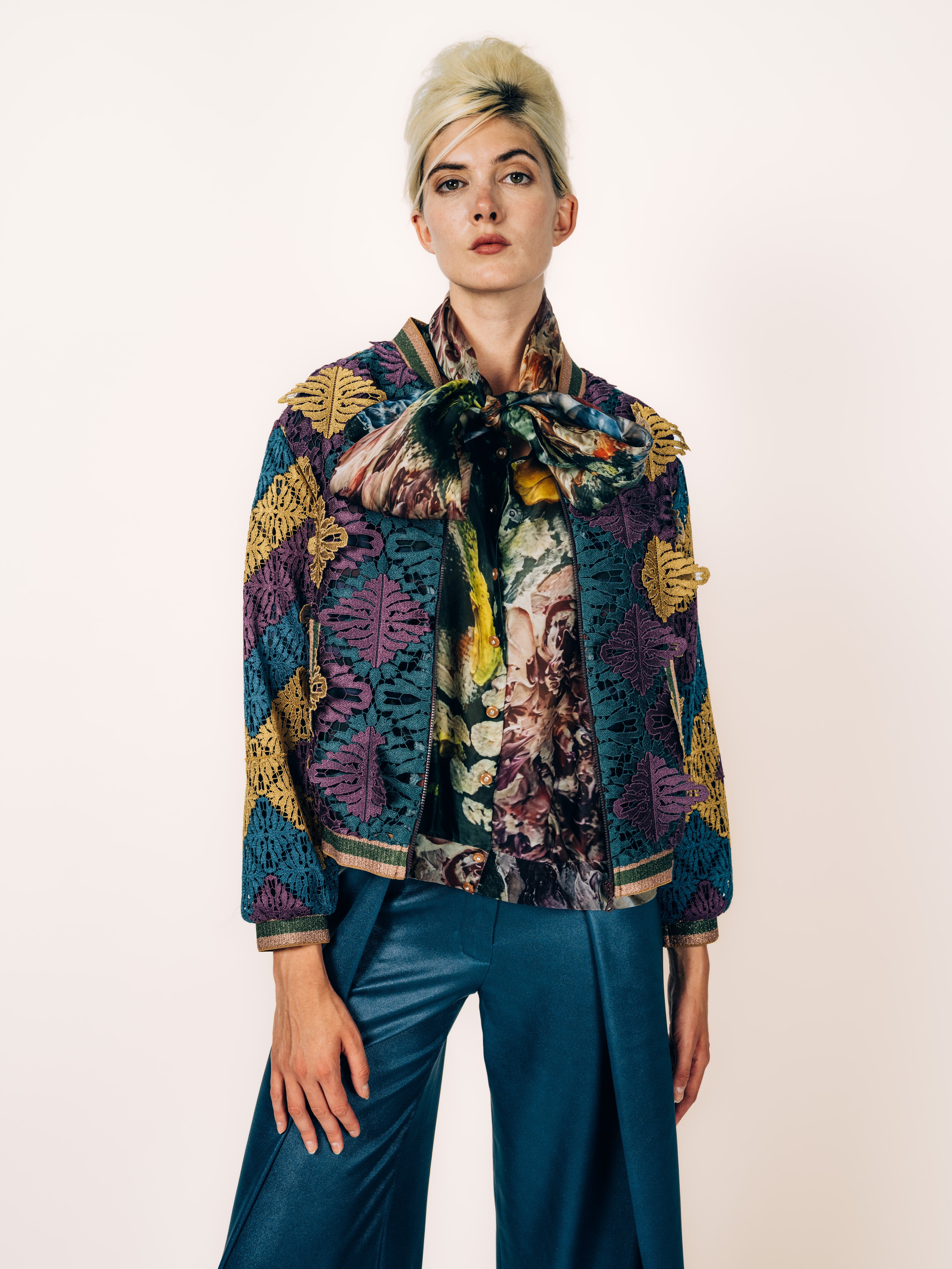 Bomberjacke aus St. Galler Stickerei in Petrol, Aubergine und Gold mit Organza-Schluppenbluse und Seidenhose von Maya Seyferth