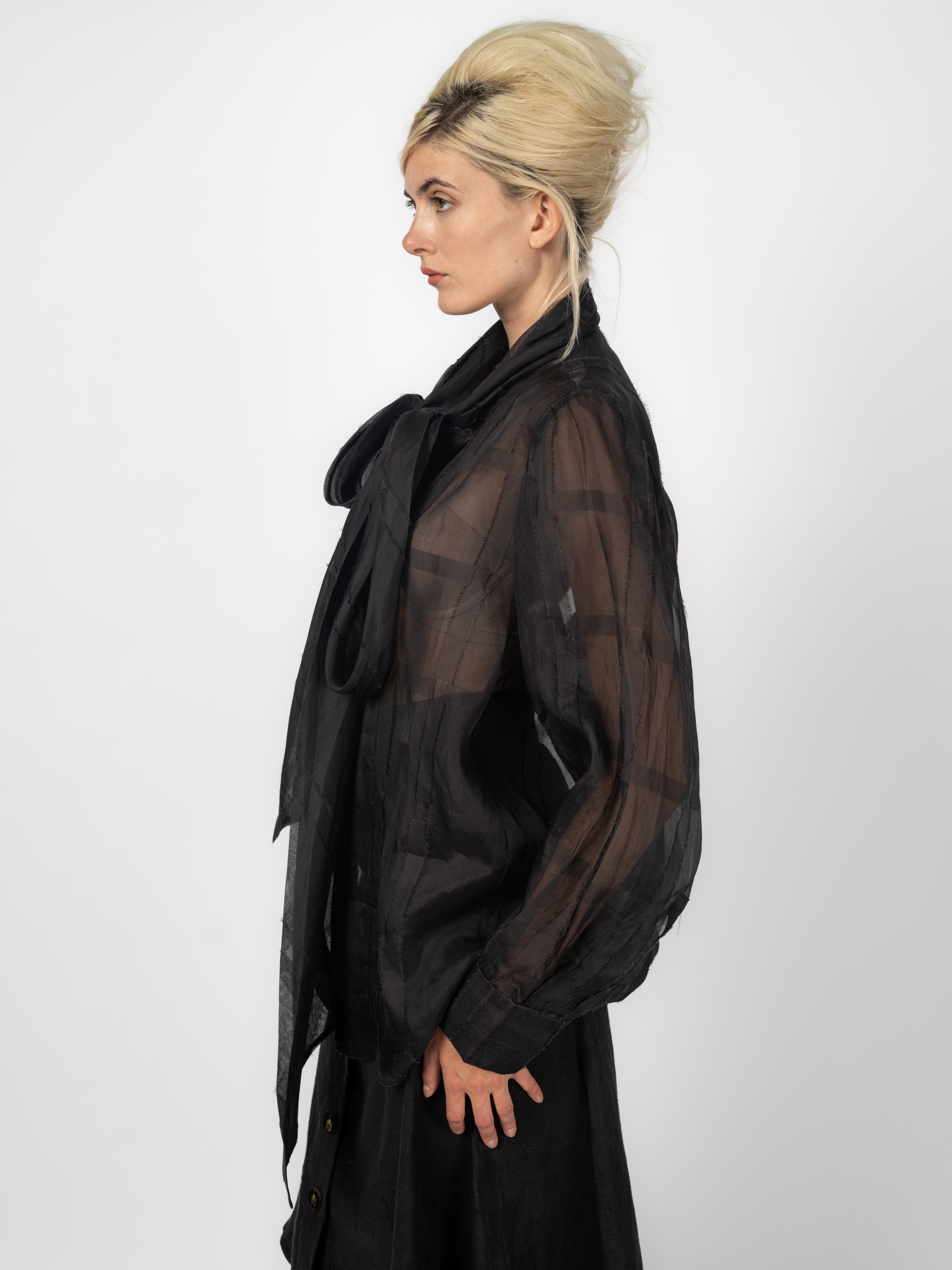Look von Maya Seyferth: Schwarze Chiffonbluse mit Schluppe und Leinenrock mit Logo-Knöpfen