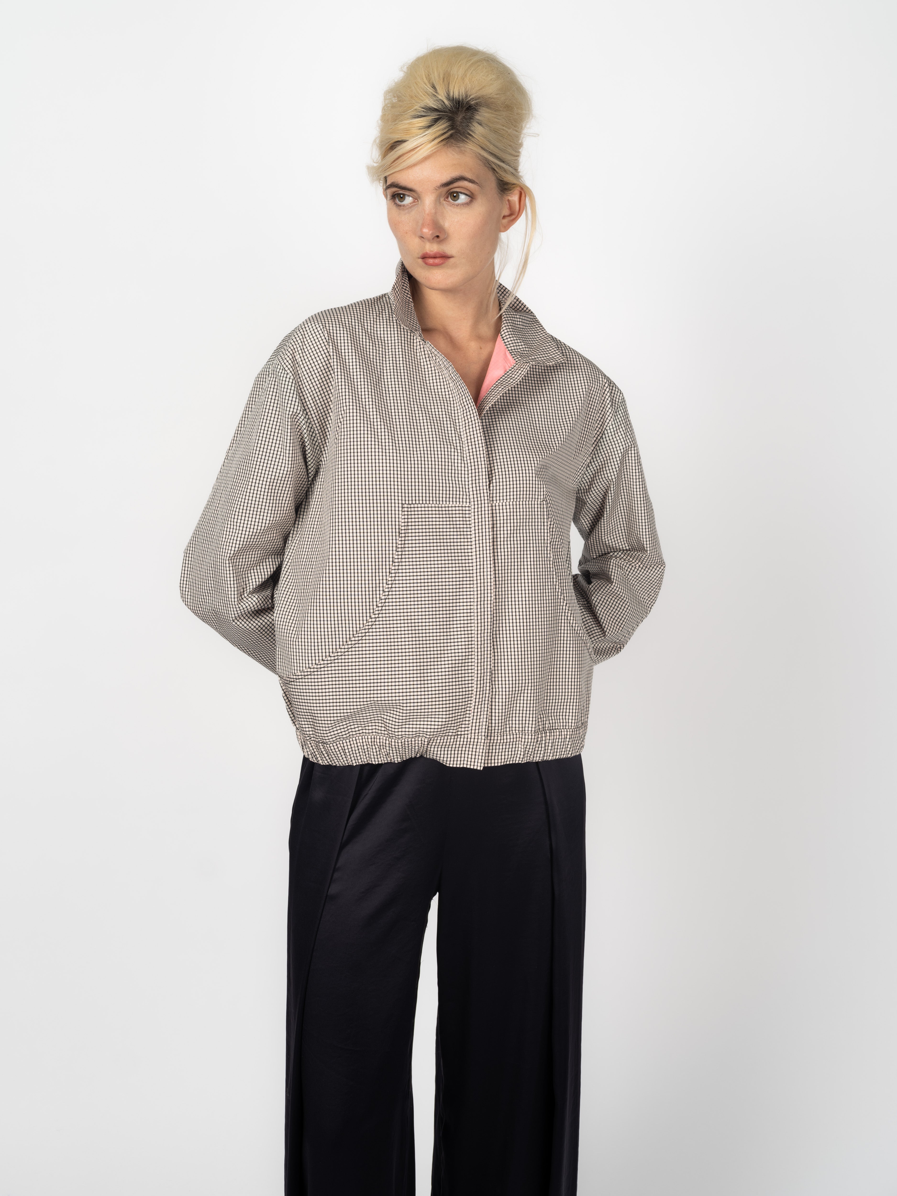 Kurzjacke im Karomuster Schwarz und Weiss mit Stehkragen und rosa Futter, kombiniert mit schwarzer Seidenhose, von Maya Seyferth