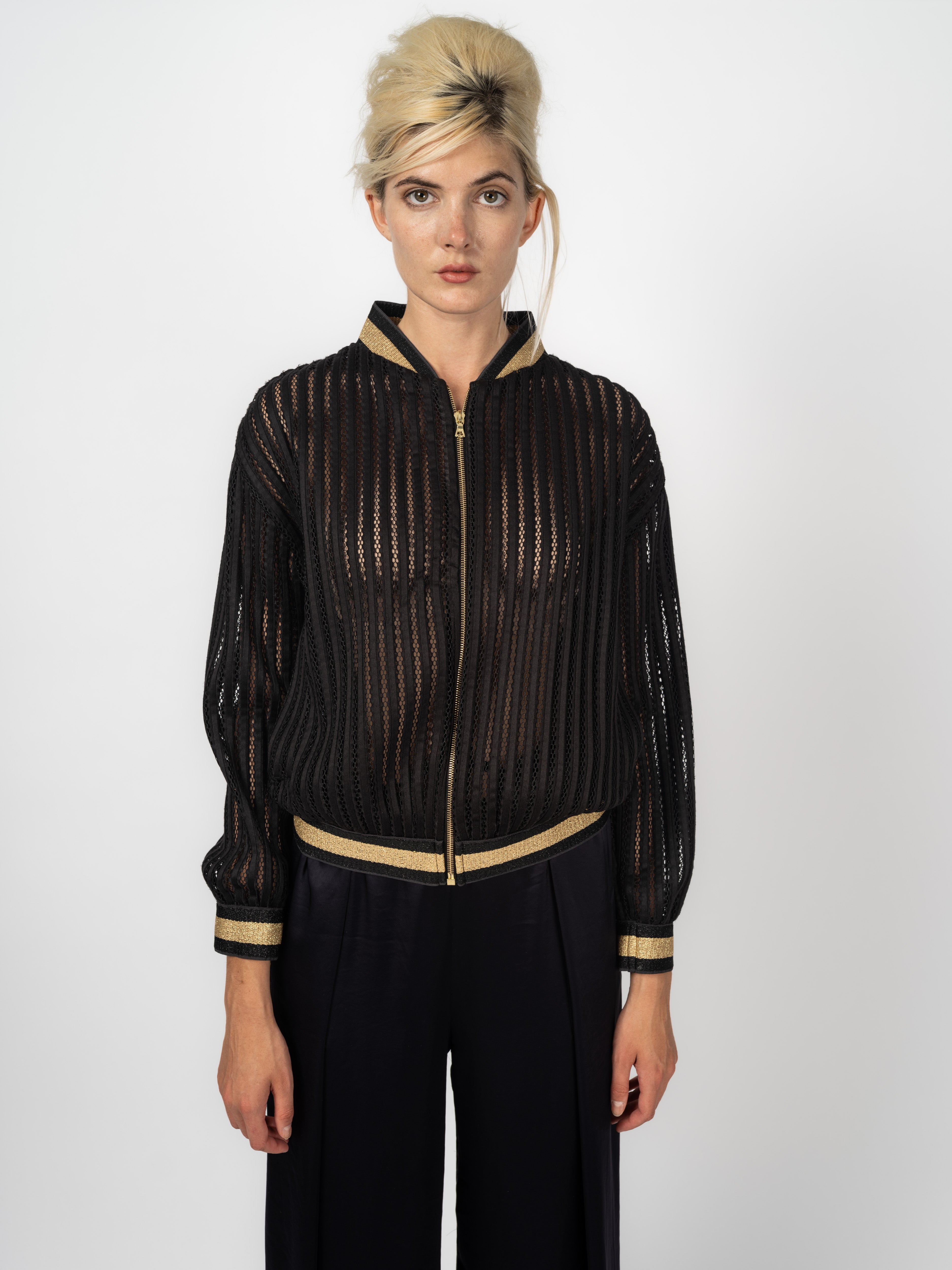 Bomberjacke Schwarz mit Netzstreifen und goldenen Bündchen, kombiniert mit schwarzer Seidenhose, von Maya Seyferth