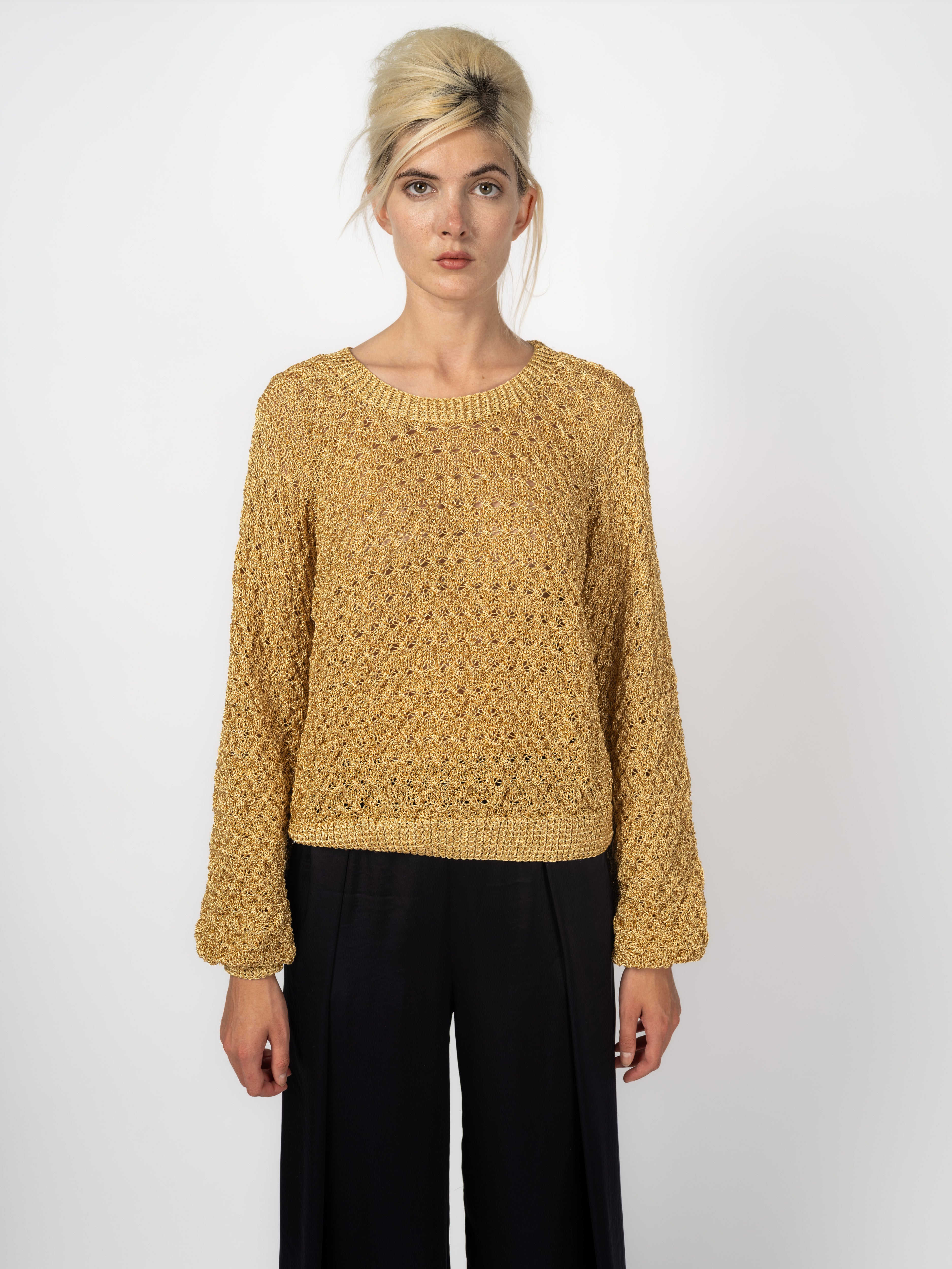 Handgefertigter Pullover aus goldenem Lurex mit Ajourmuster und Ballonärmeln, kombiniert mit schwarzer Seidenhose, von Maya Seyferth
