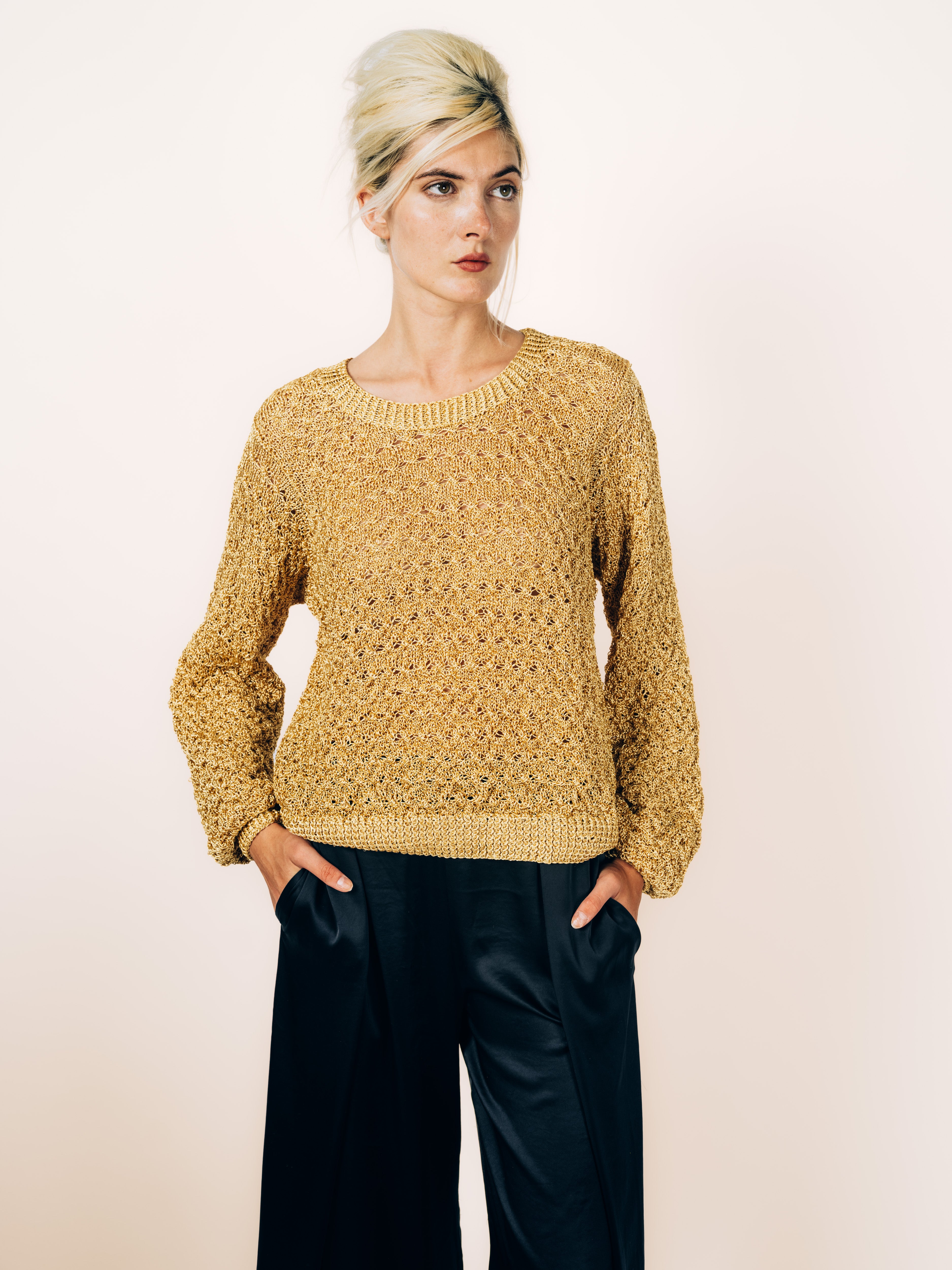 Handgefertigter Pullover aus goldenem Lurex mit Ajourmuster und Ballonärmeln, kombiniert mit schwarzer Seidenhose, von Maya Seyferth