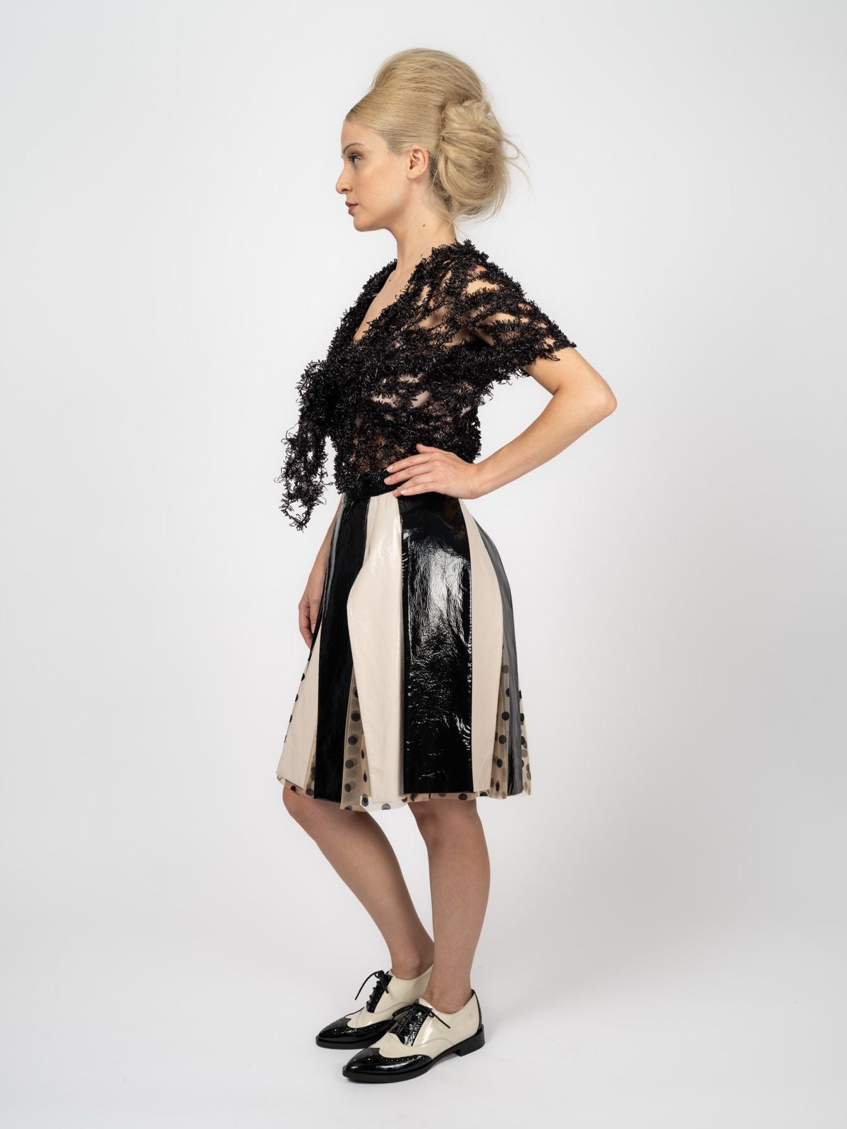 Transparentes schwarzes Top aus Fantasie-Strick mit V-Ausschnitt, kombiniert mit Rock in Schwarz und Creme, von Maya Seyferth